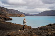 Student taking photos of a landscape with a large body of water