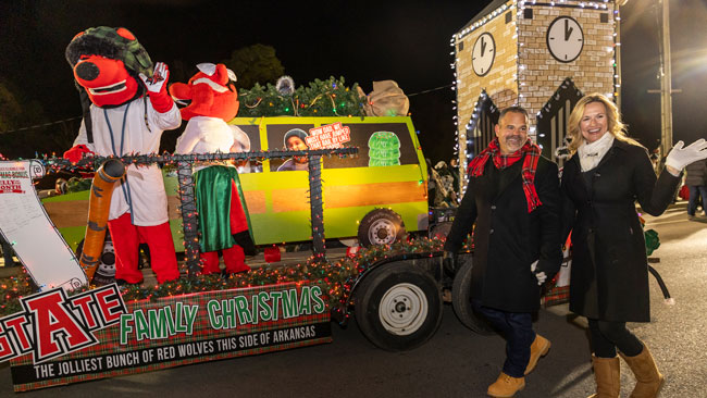 Chancellor Todd Shields and his wife Karen walk alongside the float in the parade